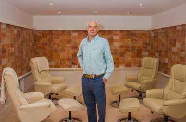 man standing in a room with chairs