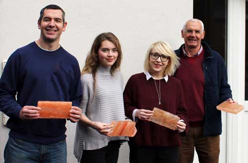 Four people holding salt blocks